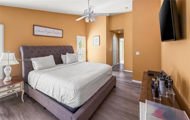 bedroom featuring lofted ceiling, wood finished floors, a ceiling fan, and baseboards