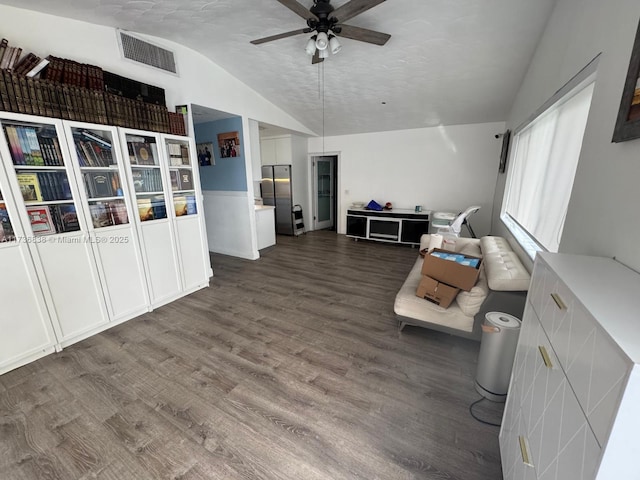 living room featuring vaulted ceiling, dark hardwood / wood-style floors, and ceiling fan