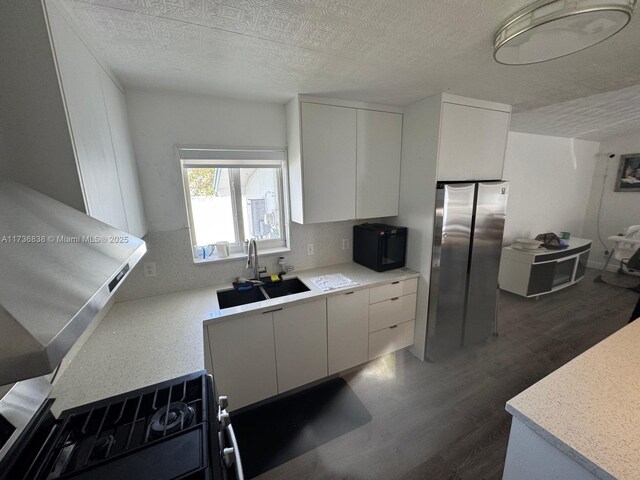 kitchen with sink, dark wood-type flooring, white cabinetry, a textured ceiling, and range with gas cooktop