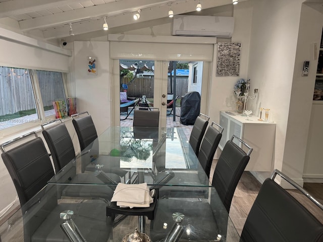 dining area featuring french doors, rail lighting, wood-type flooring, vaulted ceiling, and a wall unit AC