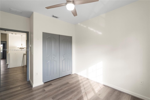 unfurnished bedroom featuring wood-type flooring, a closet, and ceiling fan