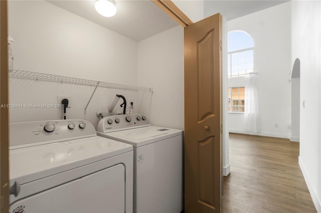 clothes washing area with separate washer and dryer and hardwood / wood-style floors