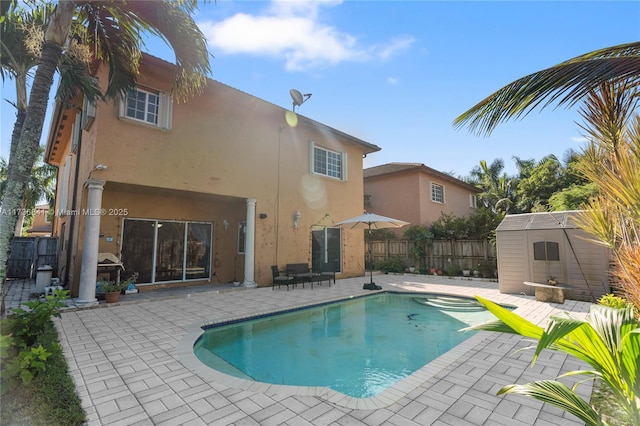 view of swimming pool featuring a patio and a shed