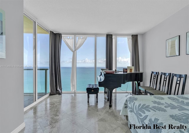 miscellaneous room with floor to ceiling windows, a textured ceiling, and a water view