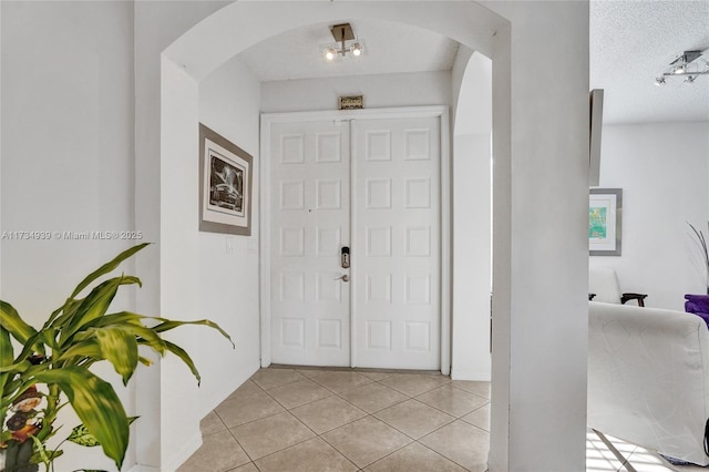 tiled entryway featuring a textured ceiling