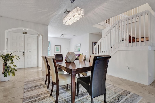 tiled dining space with a textured ceiling