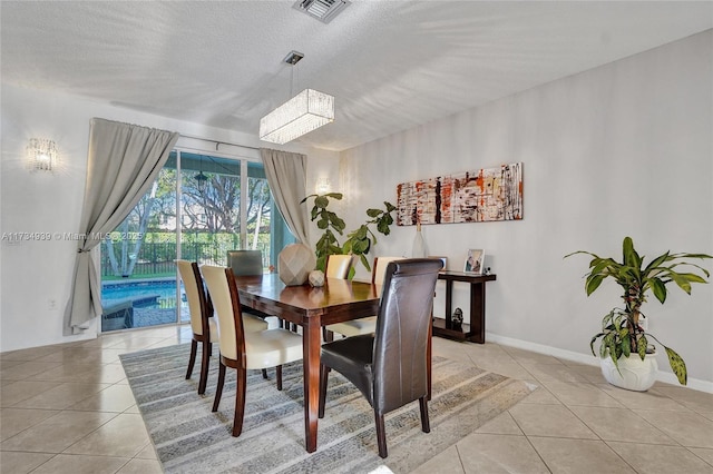 tiled dining space featuring a textured ceiling