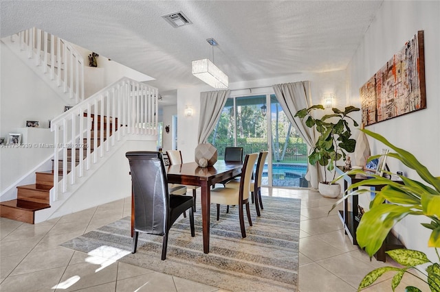 dining room with light tile patterned floors and a textured ceiling