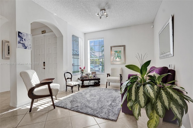 sitting room featuring a textured ceiling and light tile patterned floors