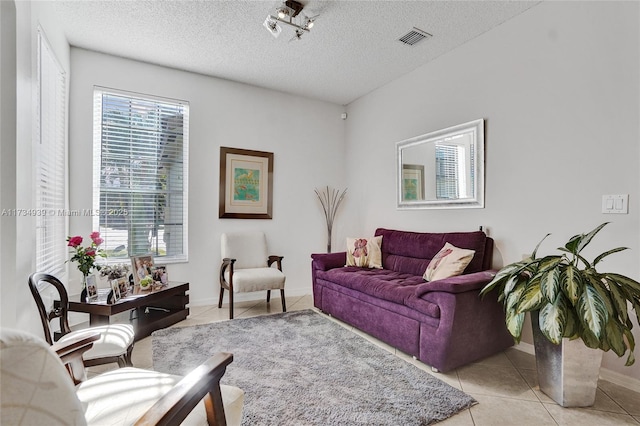 living room with light tile patterned flooring and a textured ceiling