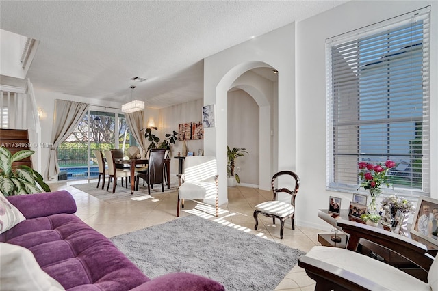 living room with a textured ceiling and light tile patterned flooring