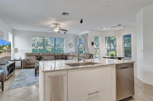 kitchen with dishwasher, sink, white cabinets, a kitchen island with sink, and light tile patterned floors