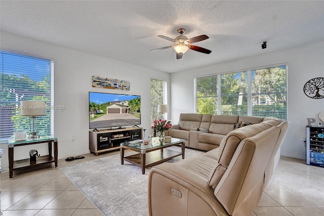 tiled living room with a healthy amount of sunlight, ceiling fan, and a textured ceiling