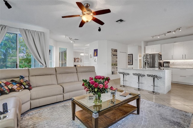 living room featuring light tile patterned flooring and ceiling fan