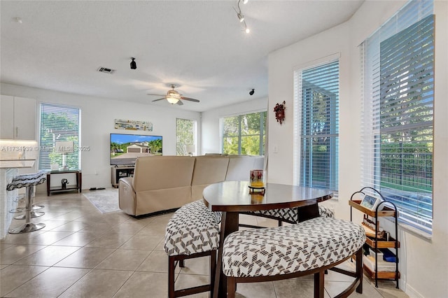 tiled dining space with ceiling fan