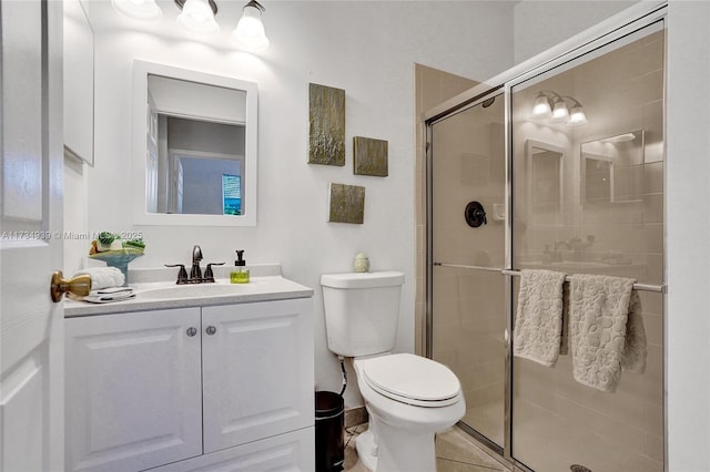 bathroom featuring vanity, toilet, tile patterned flooring, and a shower with door