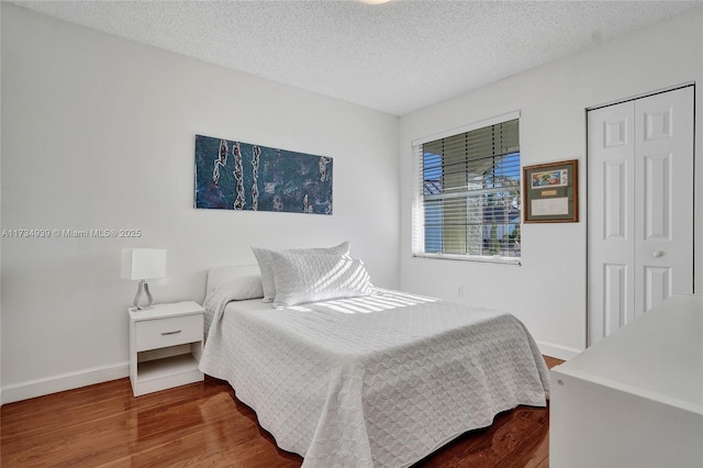 bedroom with hardwood / wood-style flooring, a textured ceiling, and a closet