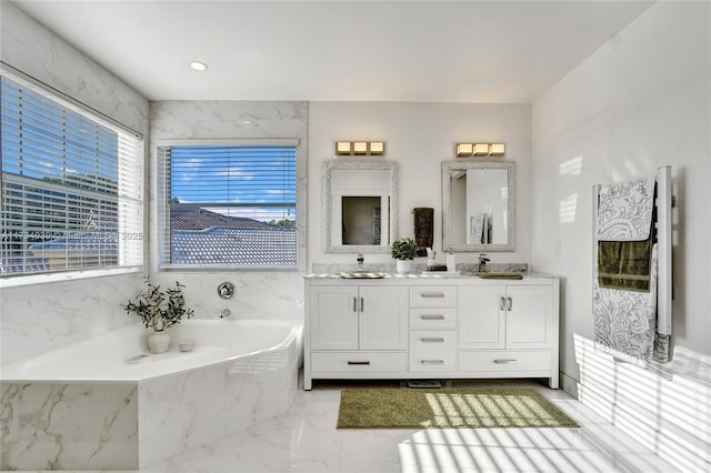 bathroom featuring vanity and tiled tub