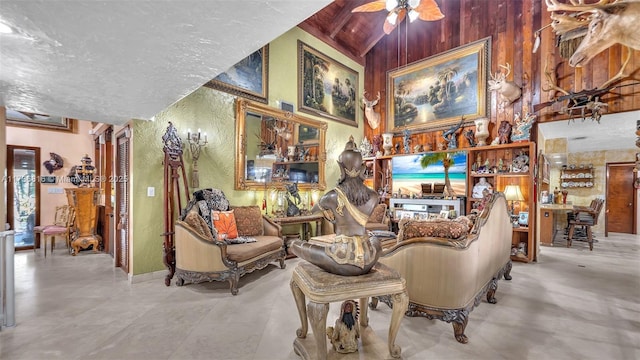 living room with a towering ceiling, a textured ceiling, and ceiling fan