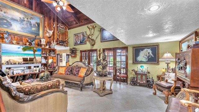 living room featuring french doors, ceiling fan, high vaulted ceiling, and a textured ceiling