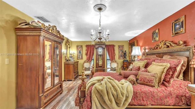 bedroom with wood-type flooring, a chandelier, and access to outside