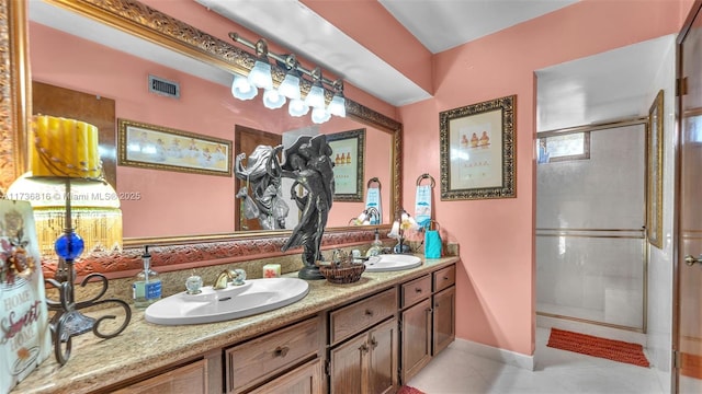 bathroom featuring a shower with door, vanity, and tile patterned flooring