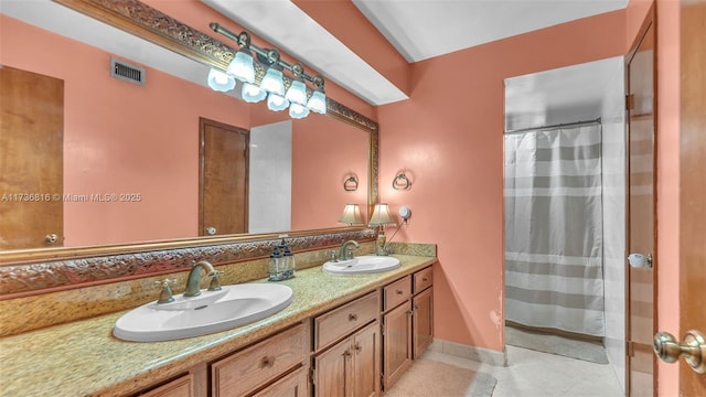 bathroom with tile patterned flooring, vanity, and walk in shower