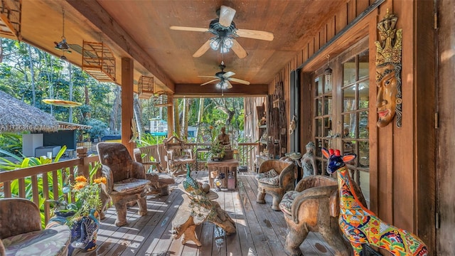 sunroom featuring ceiling fan and wooden ceiling