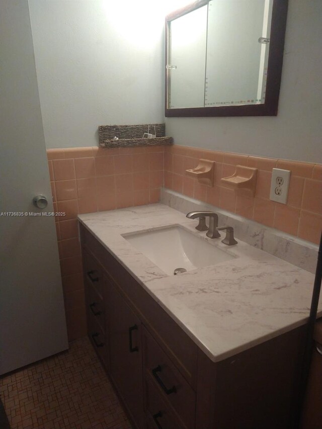 bathroom featuring vanity and tile walls