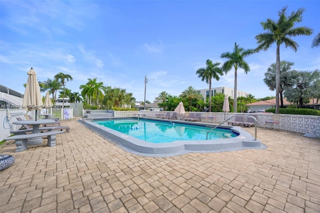 pool with a patio and fence