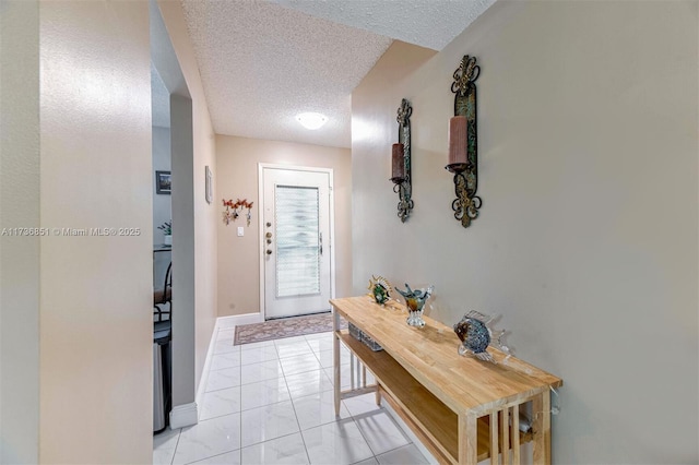 entryway with a textured ceiling and light tile patterned floors