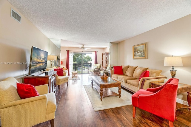 living room with ceiling fan, dark hardwood / wood-style floors, and a textured ceiling