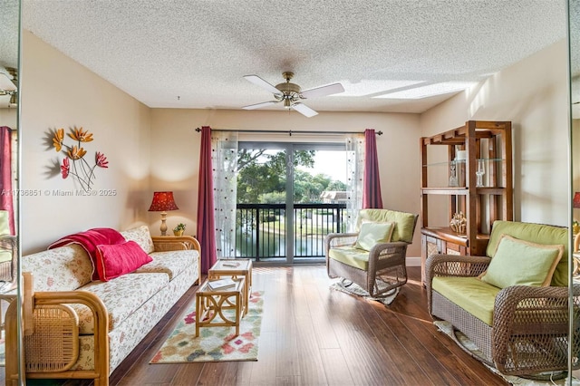 living area featuring ceiling fan, dark wood-style flooring, and a textured ceiling