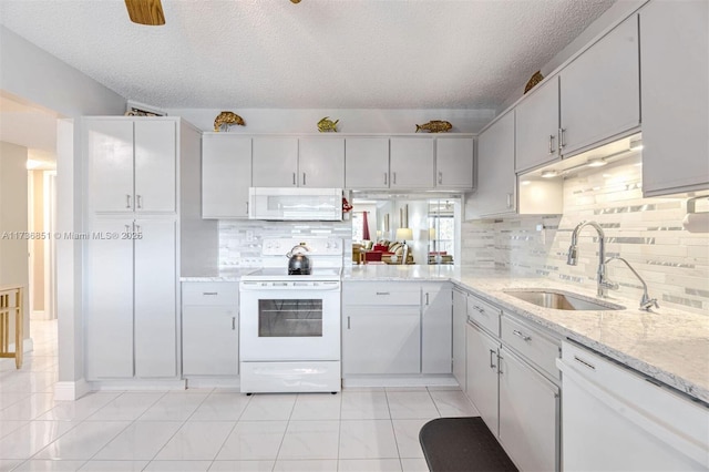 kitchen with backsplash, white cabinets, a sink, a textured ceiling, and white appliances