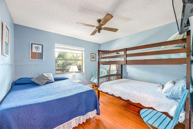 bedroom featuring ceiling fan, a textured ceiling, and wood finished floors