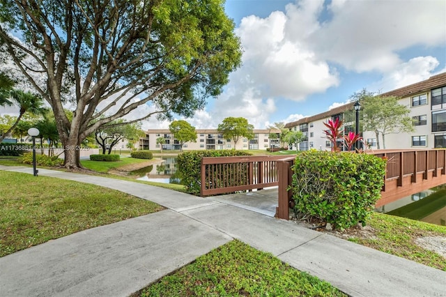 view of community with a yard and a water view