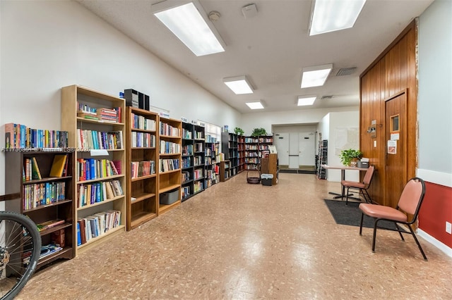 sitting room featuring visible vents, bookshelves, and tile patterned floors