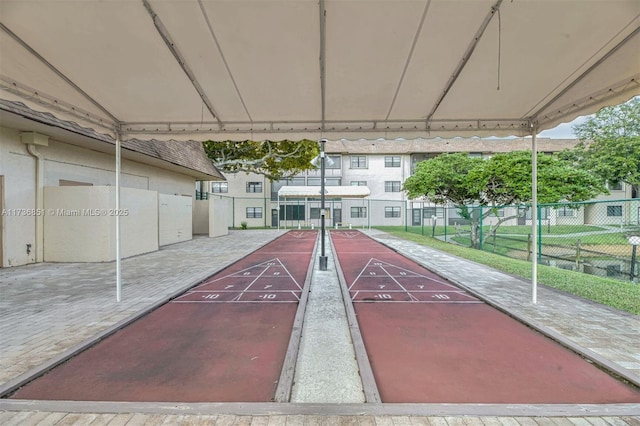 view of home's community featuring fence and shuffleboard