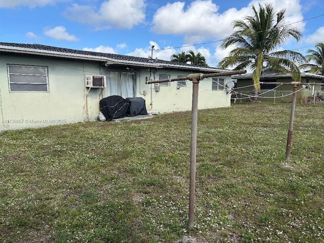 view of property exterior with a yard and a wall unit AC