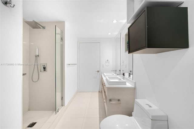 bathroom featuring vanity, toilet, tile patterned flooring, and a tile shower