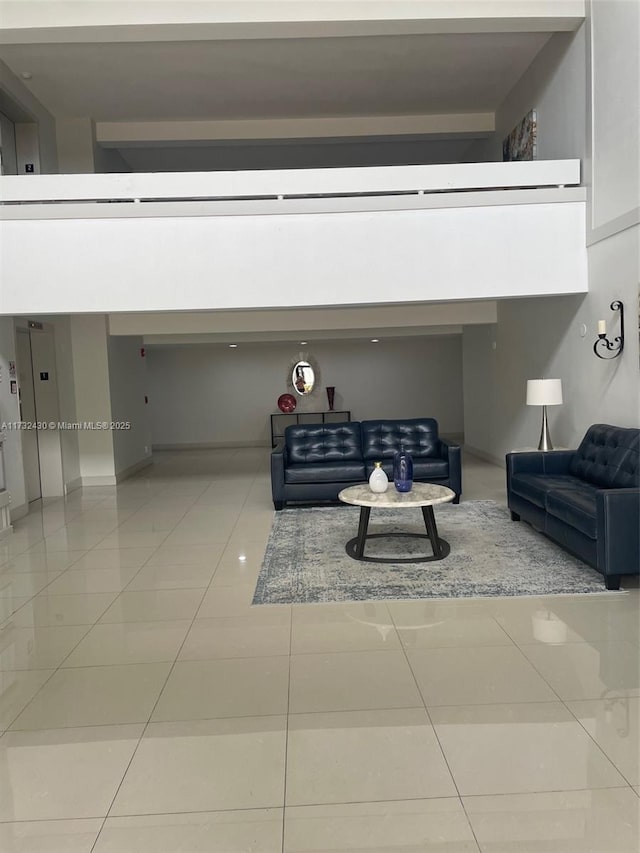 living room featuring a high ceiling, elevator, and tile patterned floors