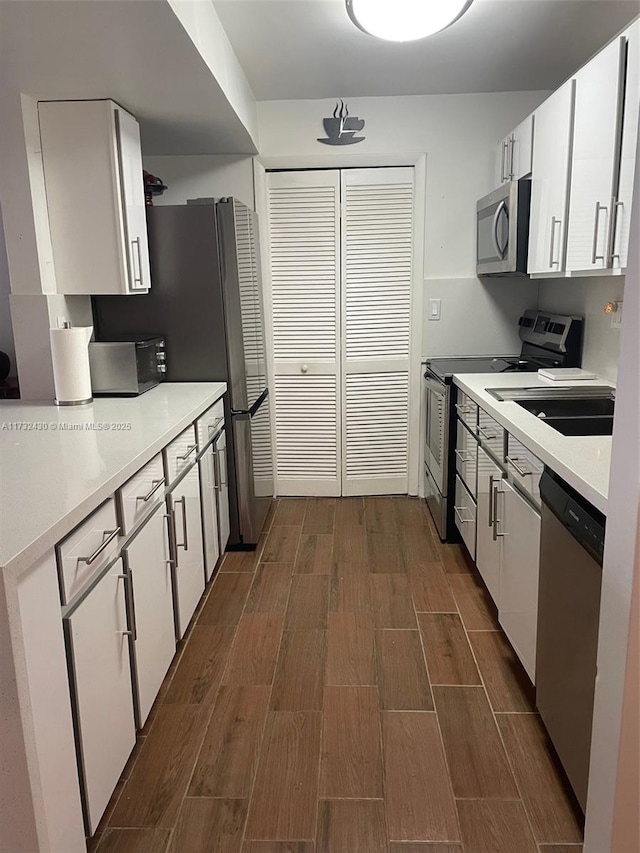 kitchen featuring stainless steel appliances and white cabinetry