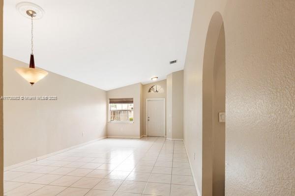 doorway to property featuring a garage and a lawn