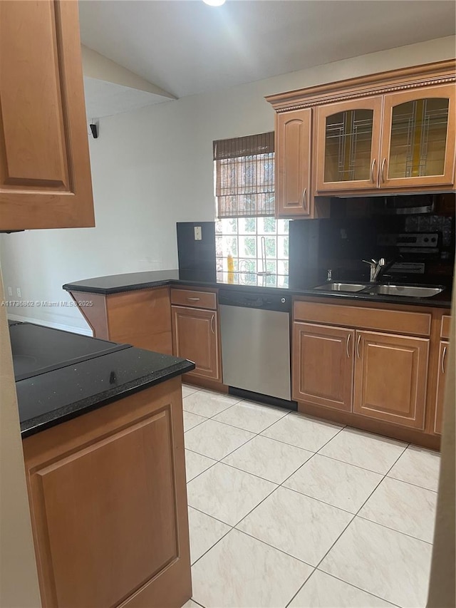 kitchen with tasteful backsplash, dishwasher, sink, dark stone countertops, and light tile patterned floors