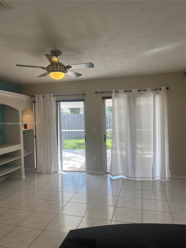 tiled spare room featuring ceiling fan and a textured ceiling