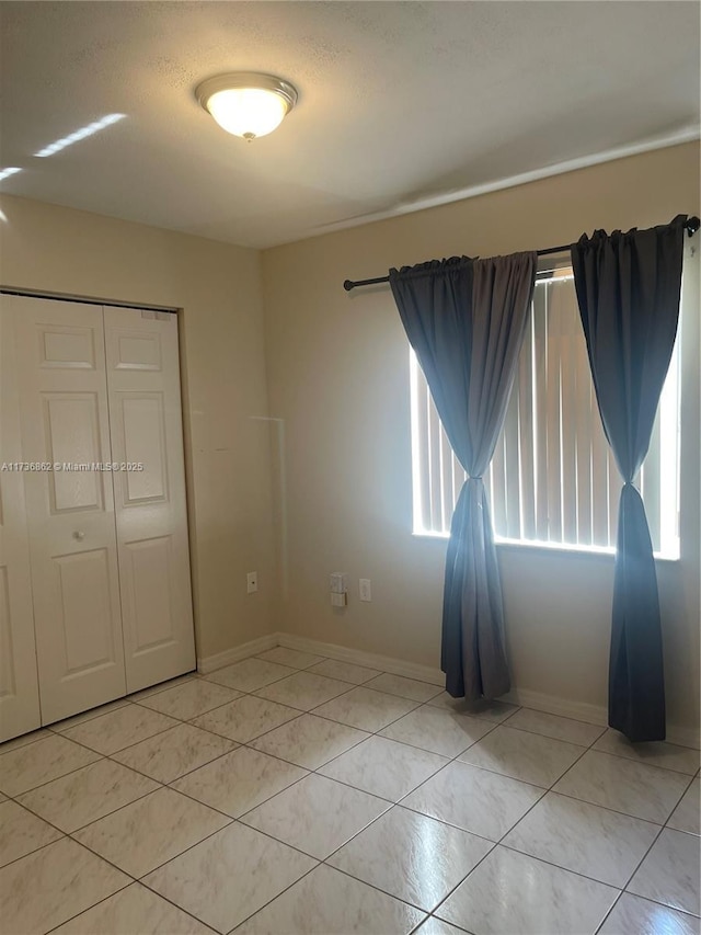 unfurnished bedroom with a closet and light tile patterned floors