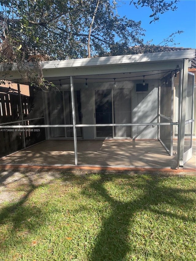 rear view of property with a sunroom and a yard