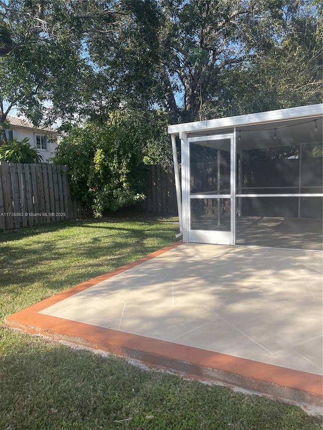 view of yard with a sunroom and fence