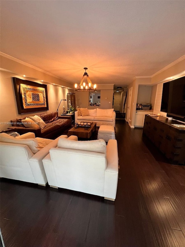 living room featuring dark hardwood / wood-style flooring, ornamental molding, and a chandelier