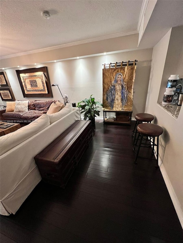 corridor featuring crown molding, wood-type flooring, and a textured ceiling